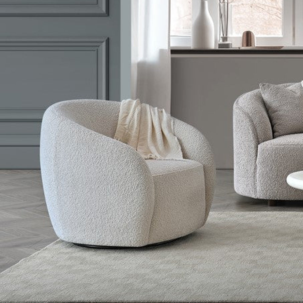 Modern beige armchair in a living room setting with a neutral color palette.